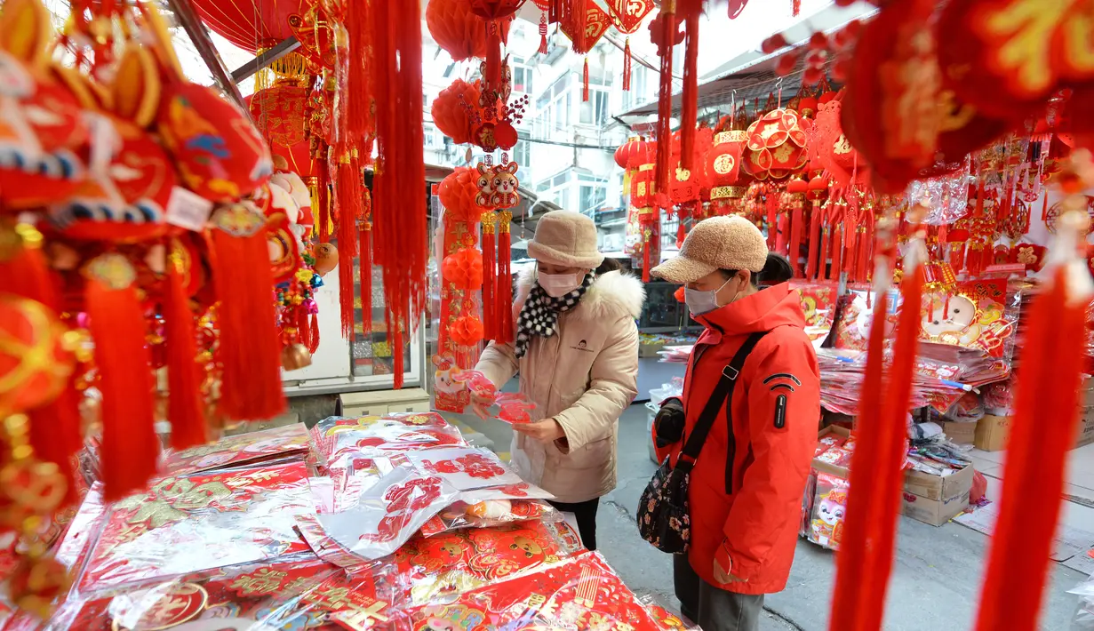 Orang-orang membeli pernak-pernik dekorasi menjelang Hari Tahun Baru di sebuah pasar di Qingdao, di provinsi Shandong timur China pada 25 Desember 2022. Warga China mulai berburu pernak-pernik Tahun Baru seperti lampion, kartu tahun baru, baju, dan hiasan rumah. (AFP/China Out)