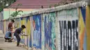 Sejumlah anak dari komunitas mural setempat saat berpatisipasi menggambar tembok yang berada di pinggir Jalan Landasan Pacu, Kemayoran, Jakarta, Rabu (11/7). (Merdeka.com/Iqbal S. Nugroho)