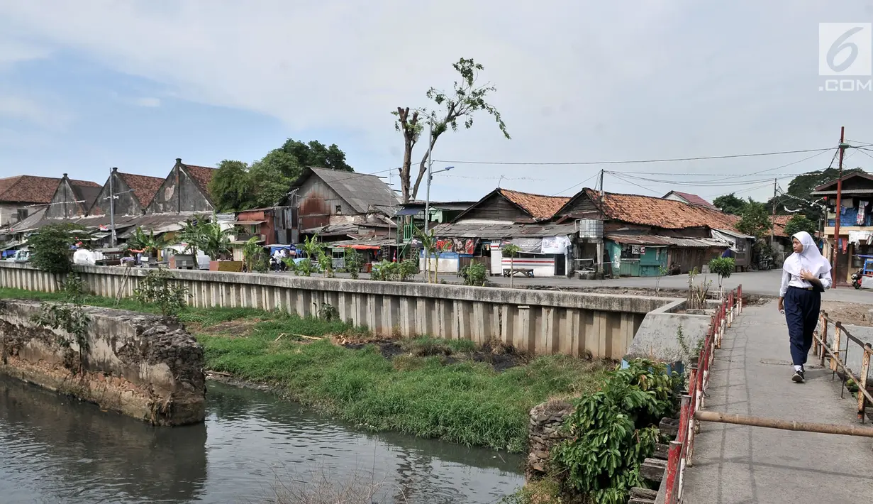 Seorang pelajar melintasi jembatan di Kali Besar Timur, kawasan Kota Tua, Jakarta, Minggu (30/9). Kondisi kali yang berada di sisi timur Kota Tua ini sangat kontras dengan Kali Besar Barat. (Merdeka.com/Iqbal Nugroho)