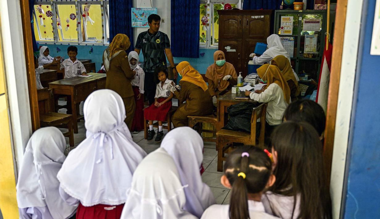 Para siswa menerima vaksin difteri di sebuah sekolah dasar di Surabaya, Jawa Timur pada Selasa 4 November 2025. Pelaksanaan program Bulan Imunisasi Anak Sekolah (BIAS) untuk tahun 2025 di Kota Surabaya, Jawa Timur dilaksanakan dalam dua tahap. (Juni KRISWANTO/AFP)