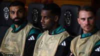 Penyerang Liverpool asal Swedia #09, Alexander Isak (tengah), terlihat dari bangku cadangan saat ia duduk di samping penyerang Liverpool asal Mesir #11, Mohamed Salah (kiri), dan gelandang Liverpool asal Argentina #10, Alexis Mac Allister (kanan), selama pertandingan putaran pertama Liga Champions antara Galatasaray (TUR) dan Liverpool (INGGRIS) di Ali Sami Yen Spor Kompleksi di Istanbul pada 17 September 2025. (Yasin AKGUL/AFP)