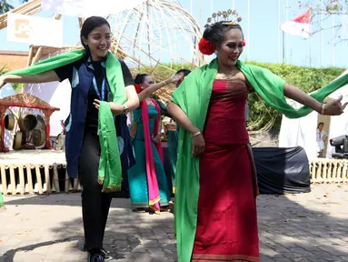 Seorang delegasi ikut menari pada pertunjukkan budaya nusantara di arena Pertemuan Tahunan IMF - World Bank 2018 di Nusa Dua Bali, Jumat (12/10). BeKraf dan LPS menyajikan beragam seni dan budaya Nusantara. (Liputan6.com/Angga Yuniar)