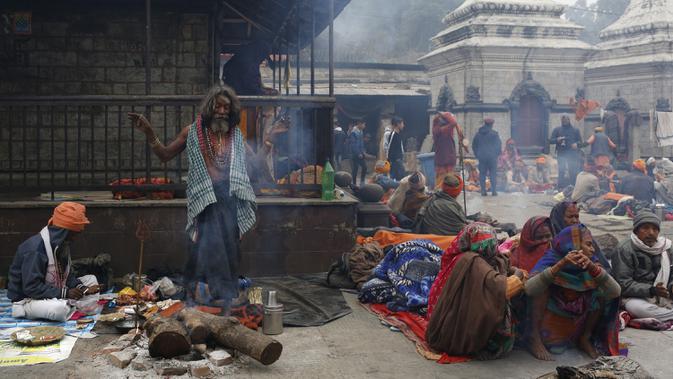 Seorang sadhu (lelaki suci Hindu) meneriakkan slogan dan tarian agama selama festival Shivaratri di lokasi kuil Pashupatinath di Kathmandu, Nepal (20/2/2020). Maha Shivaratri, sebuah festival Hindu yang dirayakan sebelum kedatangan musim semi. (AP/Niranjan Shrestha)