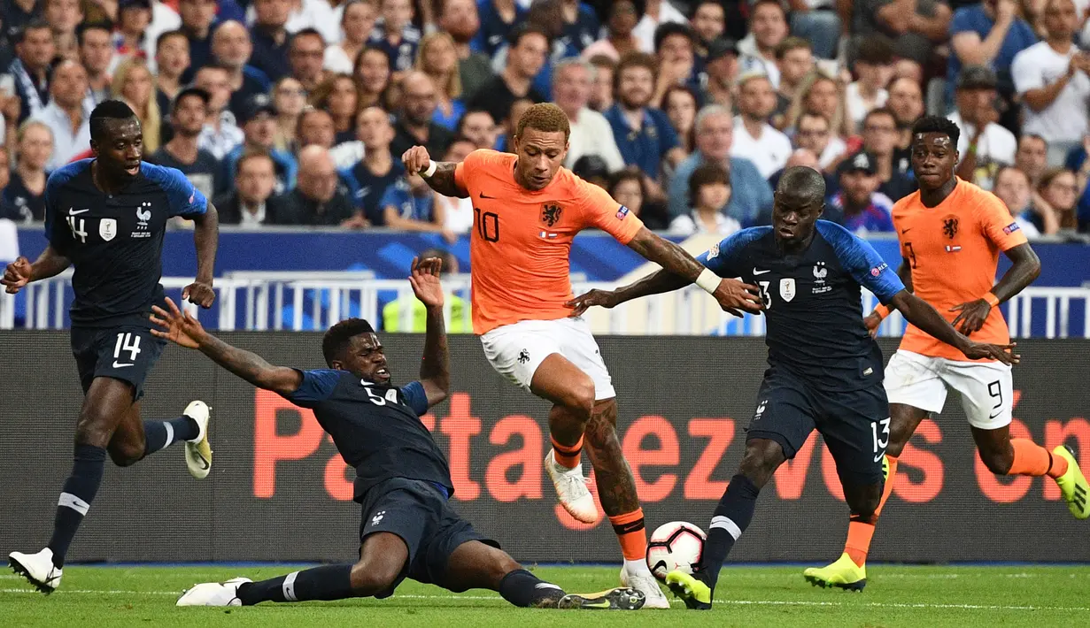 Gelandang Belanda, Memphis Depay, menghindari tekel bek Prancis, Samuel Umtiti, pada laga UEFA Nations League di Stade de France, Paris, Minggu (9/9/2018). Prancis menang 2-1 atas Belanda. (AFP/Franck Fife)