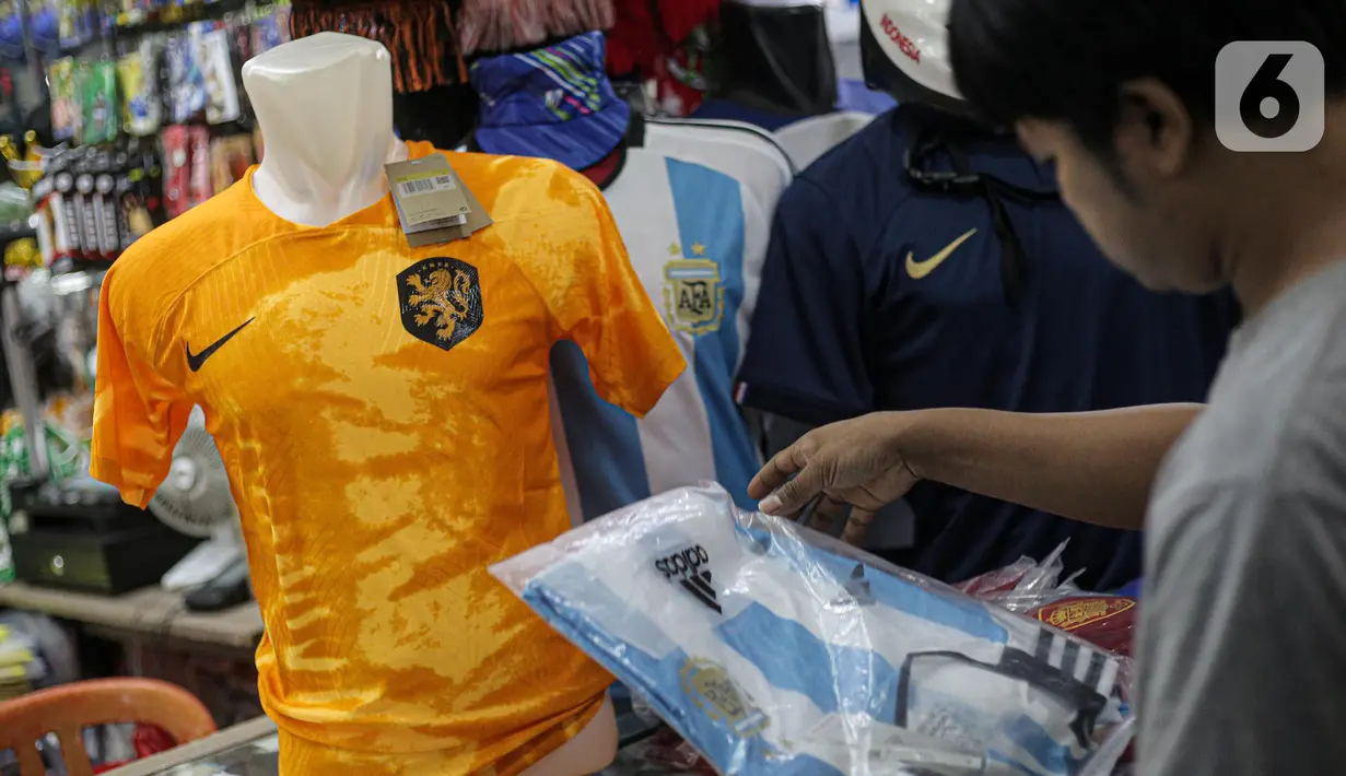Pembeli melihat jersey Argentina tim peserta Piala Dunia 2022 Qatar di salah satu kios di Blok B Pasar Tanah Abang, Jakarta, Jumat (18/11/2022). Turnamen sepak bola Piala Dunia 2022 Qatar yang akan berlangsung selama sebulan dan dimulai pada Minggu (20/11/2022) turut mendongkrak penjualan jersey. (Liputan6.com/Faizal Fanani)