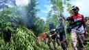 Anggota Badan Narkotika Nasional (BNN) membakar tanaman ganja saat penggerebekan pada jalur hutan di Lamteuba, Provinsi Aceh, 18 Mei 2022. (CHAIDEER MAHYUDDIN/AFP)
