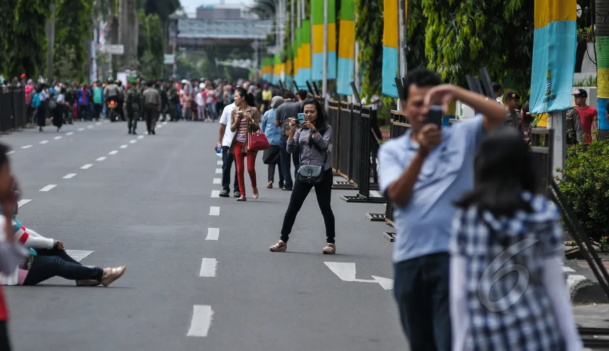 Sejumlah warga berfoto di Jalan Asia Afrika, Bandung yang sedang disterilkan dari kendaraan bermotor, Jumat (24/2015). Pensterilan jalan diberlakukan saat berlangsungnya puncak perayaan ke-60 Konferensi Asia Afrika di Bandung. (Liputan6.com/Faizal Fanani)