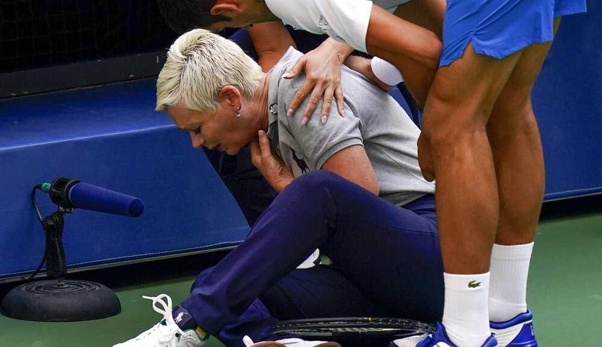 Hakim garis tampak kesakitan usai terkena bola pukulan Novak Djokovic pada AS Terbuka, di Flushing Meadows, Senin (7/9/2020). Djokovic didiskualifikasi karena memukulkan bola tenis ke arah hakim garis. (AP/Seth Wenig)