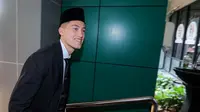 Pemain naturalisasi Indonesia, Jay Idzes memberikan senyum saat tiba di Kantor Wilayah Kementerian Hukum dan HAM, Cawang, Jakarta Timur untuk mengambil sumpah pewarganegaraan sebagai WNI pada Kamis (28/12/2023). (Bola.com/Bagaskara Lazuardi)