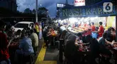 Warga menikmati waktu serta menu berbuka puasa di Sentra Kuliner Nasi Kapau di Jalan Kramat Raya, Senen, Jakarta, Senin (17/3/2025). (Liputan6.com/Herman Zakharia)