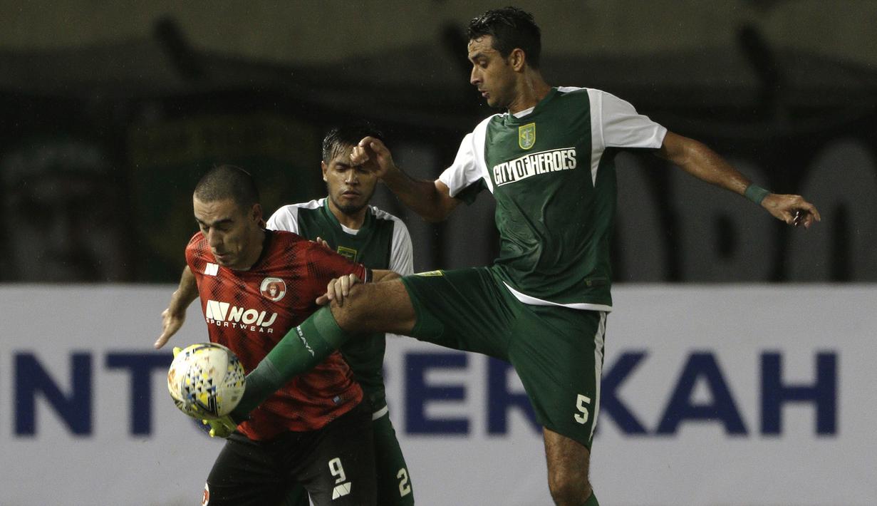 Striker Perseru Serui, Turkovic Nedo, berebut bola dengan bek Persebaya Surabaya, Otavio Dutra, pada laga Piala Presiden 2019 di Stadion Si Jalak Harupat, Bandung, Sabtu (2/3). Persebaya menang 3-2 atas Perseru. (Bola.com/Yoppy Renato)