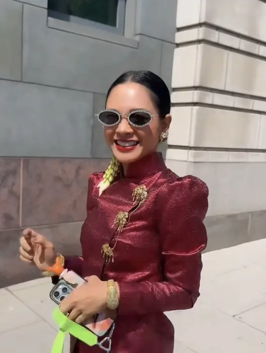 Wajahnya dipoles dengan nuansa bright, mengaplikasikan blush on pink dan lipstik merah menyala sesuai dengan warna kebayanya. Ia pun tampil slay dengan kacamata hitam. [@andienaisyah]