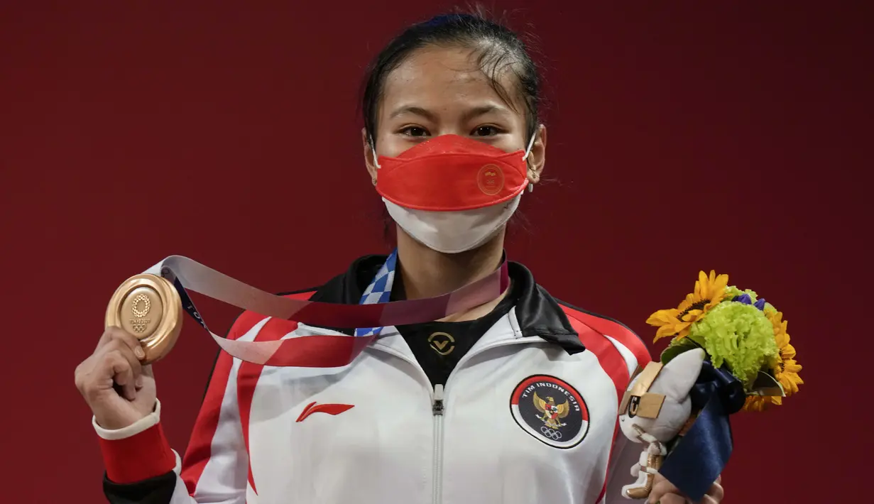 Windy Cantika Aisah yang turun di nomor 49kg putri cabang olahraga angkat besi berhasil meraih medali perunggu serta medali pertama bagi Indonesia lewat total angkatan 194 kg. (Foto: AP/Luca Bruno)