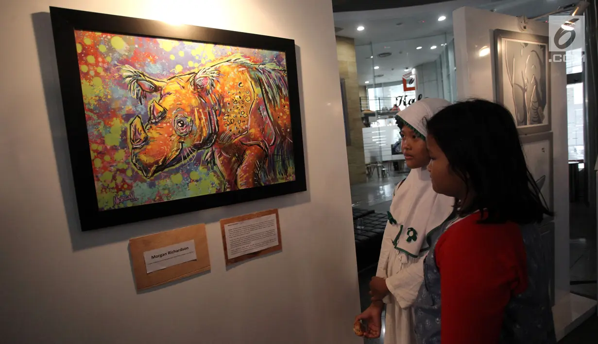Dua anak kecil melihat-lihat karya dalam pameran seni badak Sumatera di Perpustakaan Nasional Indonesia, Jakarta Pusat, Jumat (19/1). (Liputan6.com/Arya Manggala)