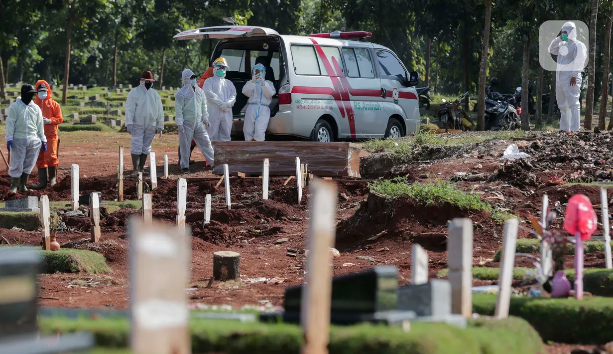 Petugas Suku Dinas Pertamanan dan Pemakaman menurunkan jenazah pasien COVID-19 di TPU Pondok Rangon, Jakarta, Rabu (17/6/2020).  Meski  Fase pertama PSBB transisi di Ibukota diberlakukan pertambahan pasien terus meningkat sampai hari ini. (Liputan6.com/Johan Tallo)