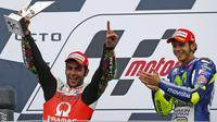 Pembalap dari Pramac Rancing, Danilo Petrucci (kiri) saat mengangkat piala juara kedua pada balapan Moto Gp seri ke-12 di sirkuit Silverstone (30/8/2015). Valentino Rossi finis pertama di seri ke-12 ini. (REUTERS/Darren Staples)