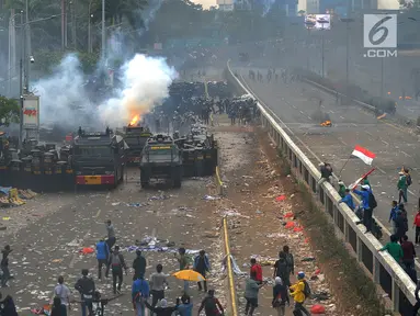 Polisi menembakkan gas air mata ke arah mahasiswa saat demonstrasi menolak pengesahan RUU KUHP dan revisi UU KPK di depan Gedung DPR, Jakarta, Selasa (24/9/2019). Polisi menghalau mahasiswa yang berusaha masuk ke area Gedung DPR. (merdeka.com/Arie Basuki)