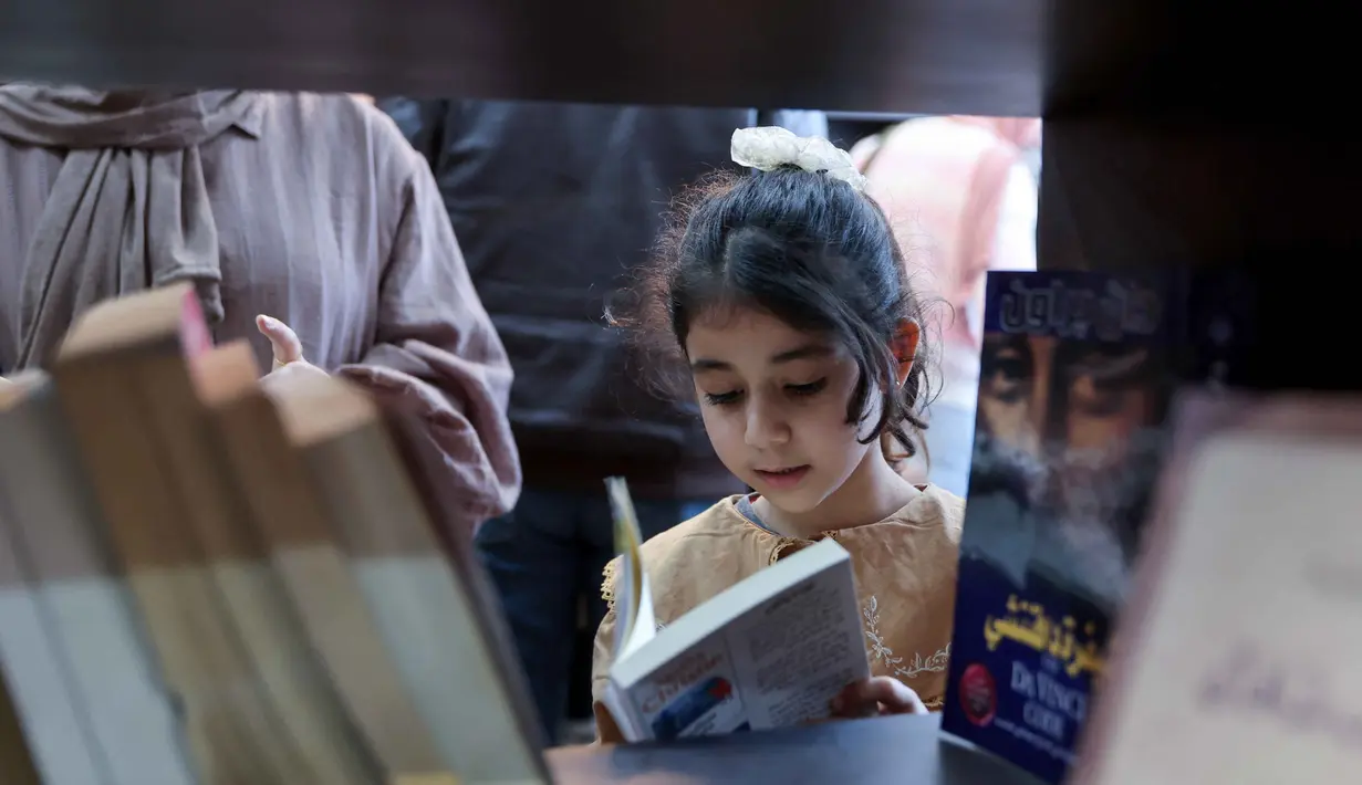Perpustakaan yang terletak di lingkungan Rimal, Kota Gaza, menjadi ruang belajar alternatif, dan harapan di tengah kehancuran akibat serangan Israel sejak Oktober 2023. Tampak dalam foto, seorang gadis pengungsi Palestina membaca buku di perpustakaan Al-Ankaa (Phoenix), perpustakaan pertama yang dibuka sejak gencatan senjata di Jalur Gaza yang berisi buku-buku yang diselamatkan dari perpustakaan yang hancur selama perang Israel-Hamas, di lingkungan Rimal, Kota Gaza pada Selasa 21 April 2026. (Omar AL-QATTAA/AFP)