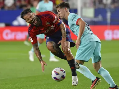 Gelandang Osasuna, Ruben Garcia dilanggar oleh gelandang Barcelona Gavi pada pekan keempat La Liga Spanyol di stadion Pamplona, Senin (4/9/2023). (AP Photo/Alvaro Barrientos)