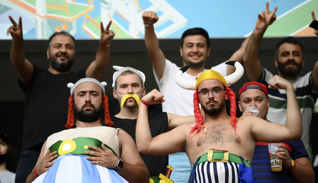 Suporter Prancis berpose di tribun penonton dengan kostum tokoh kartun Obelix dan Asterix sebelum pertandingan grup F kejuaraan sepak bola Euro 2020 antara Portugal dan Prancis di Puskas Arena, Budapest, Rabu, 23 Juni 2021. (Foto: AP/Pool/Franck Fife)