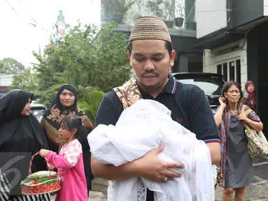 Presenter Indra Bekti menggendong jenazah anak ketiganya menuju TPU Kamboja, Radio Dalam,  Jakarta, Rabu (1/2). Anak ketiga pasangan Indra Bekti dan Aldilla Jelita itu meninggal beberapa menit setelah dilahirkan. (Liputan6.com/Herman Zakharia)