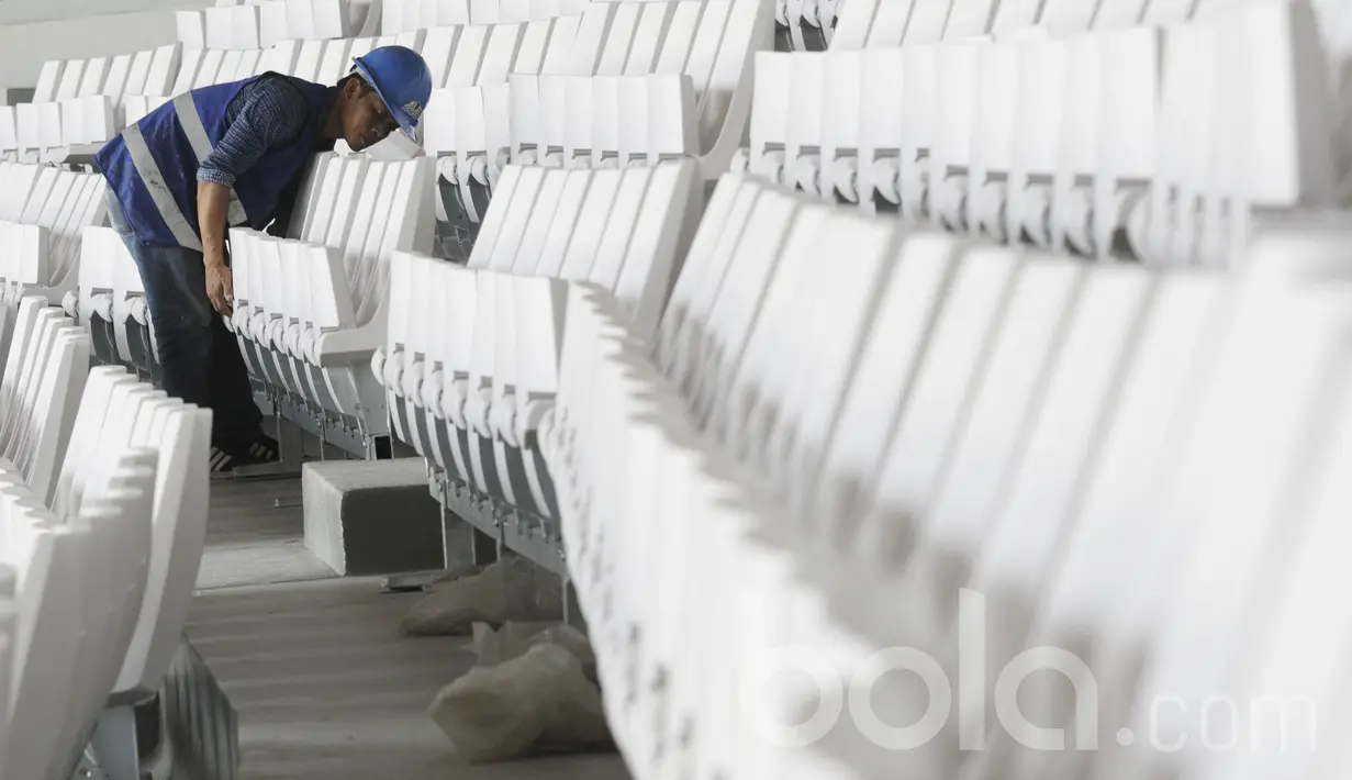 Pekerja memasang bangku di Stadion Gelora Bung Karno (SUGBK). Perhelatan Asian Games akan diselenggarakan pada tanggal 18 Agustus 2018 sampai 2 September 2018. (Bola.com/M Iqbal Ichsan)
