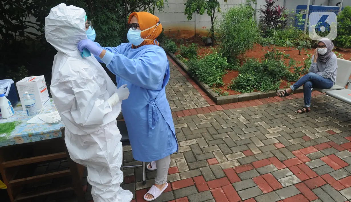 Tenaga kesehatan melakukan persiapan sebelum kegiatan tes swab massal di Puskesmas Ciganjur, Jakarta, Kamis (7/1/2020). Lonjakan kasus virus corona berpotensi terjadinya krisis tenaga kesehatan (nakes) karena banyak yang tertular dan gugur saat menangani pasien Covid-19. (merdeka.com/Arie Basuki)