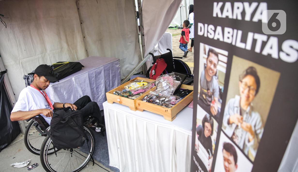 Penyandang disabilitas menjaga booth pada acara puncak peringatan Hari Disabilitas Internasional 2019 di Plaza Barat Gelora Bung Karno, Jakarta, Selasa (3/12/2019). Acara ini mengangkat tema 'Indonesia Inklusi, Disabilitas Unggul'. (Liputan6.com/Faizal Fanani)
