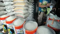 Seorang pedagang menimbang beras di Pasar Sederhana, Bandung, Jabar. Harga bahan kebutuhan pokok seperti beras, sayuran, daging dan telur merangkak naik menjelang datangnya bulan puasa.(Antara)