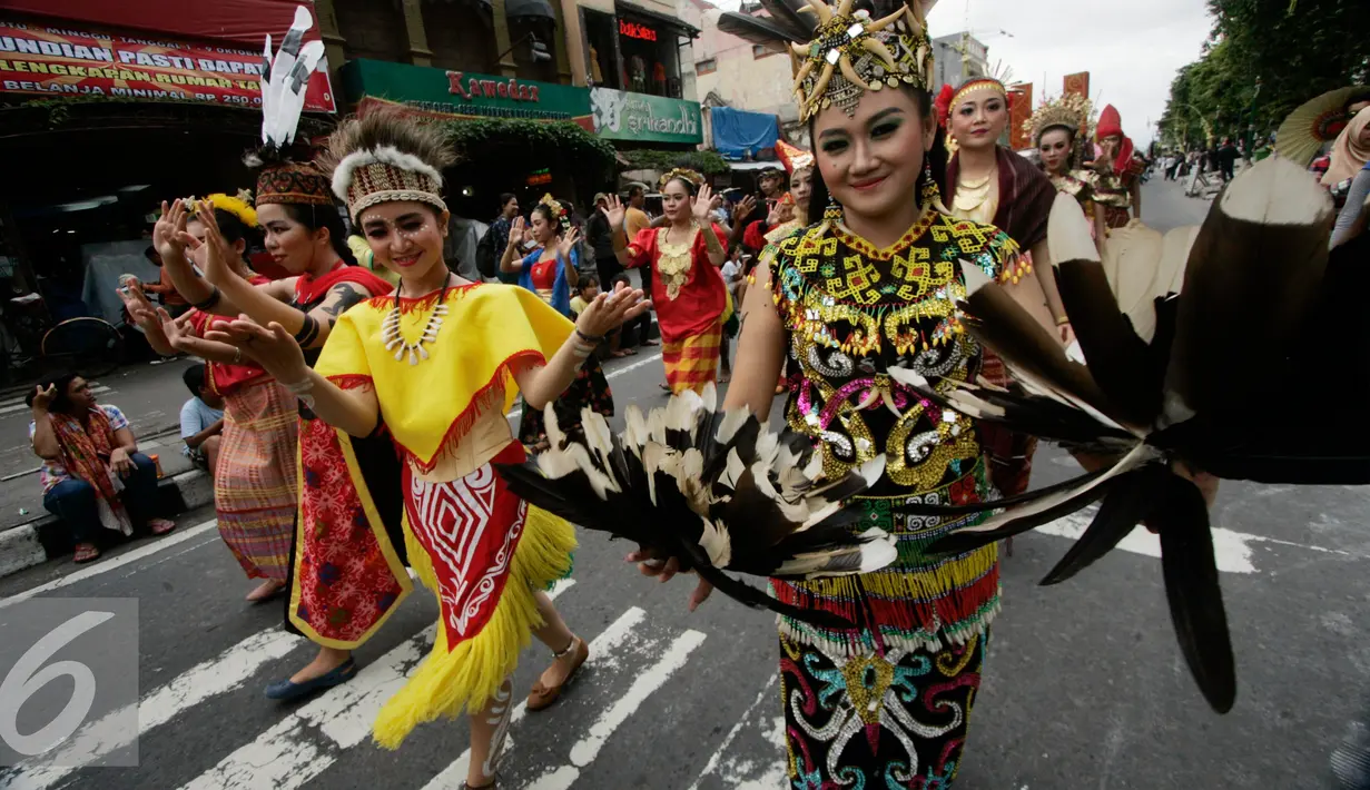 Peserta mengenakan kostum Dayak ikut meramaikan pawai selendang sutera di jalan malioboro, Yogyakarta, Kamis (06/10). Pawai diselenggarakan dalam rangka hari museum Indonesia yang akan digelar hingga 12 Oktober mendatang. (Liputan6.com/Boy Harjanto)