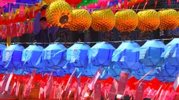 Pekerja memasang lampion di Jogye Temple jelang perayaan ulang tahun Buddha, Seoul, Rabu (12/4). Di Negeri Ginseng ini, ulang tahun Buddha dirayakan dengan menggelar ‘Lotus Lantern Festival’. (AFP PHOTO / JUNG Yeon-Je) 