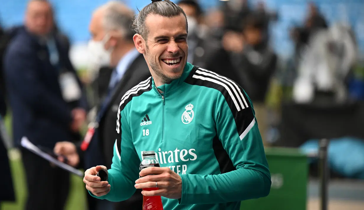 <p>Striker Real Madrid, Gareth Bale tersenyum saat menghadiri sesi latihan tim di Stadion Etihad di Manchester, Inggris barat laut, pada 25 April 2022. Real Madrid akan bertanding melawan Manchester City pada leg pertama semifinal Liga Champions. (AFP/Oli Scarff)</p>