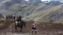 Seorang turis wanita menunggang kuda saat berwisata di Gunung Pelangi di Pitumarca, Peru (2/4). Rainbow Mountain atau Gunung Pelangi terbentuk sekitar 24 juta tahun lalu, akibat gempa tektonik. (AP Photo/Martin Mejia)