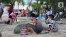 Anak-anak bermain pasir di Pantai Indah Taman Impian Jaya Ancol, Jakarta, Kamis (29/10/2020). Libur panjang di masa pemberlakuan PSBB transisi Jakarta dimanfaatkan warga untuk mengunjungi lokasi-lokasi wiisata. (Liputan6.com/Helmi Fithriansyah)