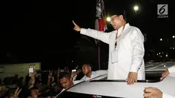 Calon Presiden Prabowo Subianto menyapa pendukungnya di sepanjang jalan Imam Bonjol usai pengambilan nomor urut di Gedung KPU Jakarta, Jumat (21/9). Prabowo memberikan salam 2 jari dengan mobil warna putih. (Liputan6.com/Fery Pradolo)