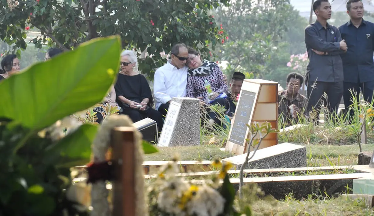 Di TPU Karet Bivak, Jakarta, Budi Mulya tampak memeluk istrinya, Anne Mulya yang terus menangis, (8/9/14). (Liputan6.com/Miftahul Hayat)