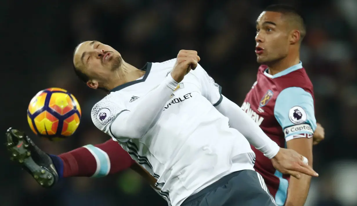 Striker Manchester United, Zlatan Ibrahimovic, duel udara dengan bek West Ham, Winston Reid. Walaupun unggul jumlah pemain, namun Setan Merah gagal mencetak sebuah gol hingga babak pertama usai. (Reuters/Eddie Keogh)