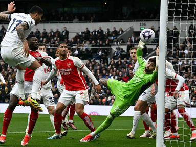 Kiper Arsenal, David Raya berusaha mementahkan bola hasil sundulan pemain Tottenham Hotspur, Cristian Romero pada laga lanjutan Liga Inggris 2023/2024 di Tottenham Hotspur Stadium, London, Inggris, 28 April 2024. (AFP/Ben Stansall)
