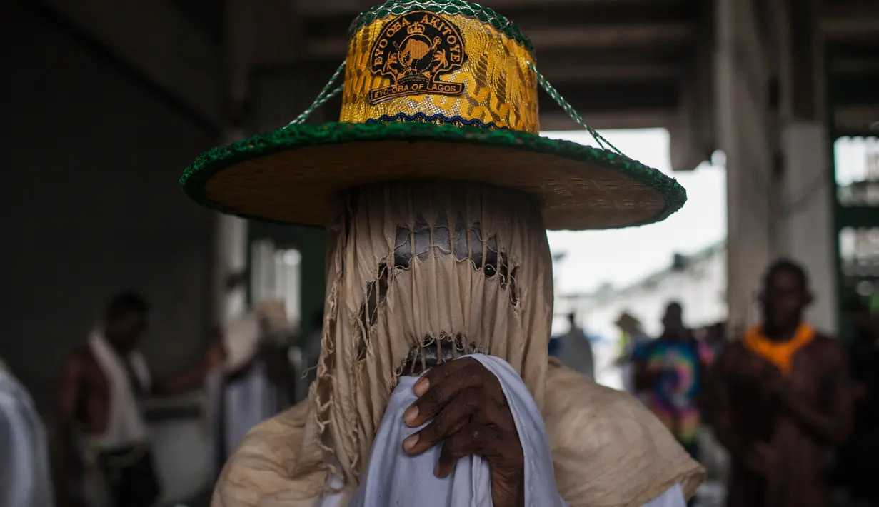 Seorang Eyo masqueraders bersiap mengikuti Festival Eyo di Tafawa Balewa Square di Lagos, Nigeria (20/5). Para peserta yang berpakaian putih ini mewakili roh orang mati yang disebut Yoruba atau "agogoro Eyo". (AFP Photo/Stefan Heunis)
