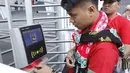 Seorang suporter menempelkan tiket ke mesin barcode saat memasuki SUGBK, Senayan, Jakarta, Minggu (14/1/2018). Fasilitas baru tersebut untuk meningkatkan keamananan, kenyamanan serta kedisiplinan suporter. (Bola.com/M Iqbal Ichsan)