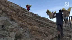 Penambang mengangkut  belerang  di Kawah Ijen, Banyuwangi, Jawa Timur Senin (2/7). Para penambang mampu mengambil dan mengangkut belerang setiap harinya sebanyak 150 - 200 kg dengan upah Rp 100/kg. (Merdeka.com/Arie Basuki)