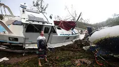 Bradley Mitchell memeriksa perahu usai diterjang Topan Debbie di Shute Harbour, Pantai Airlie, Australia, Rabu (29/3). Badai yang mengembuskan angin hingga 161 km per jam memporak-porandakan puluhan bangunan di pesisir. (Dan Peled/AAP Image via AP)