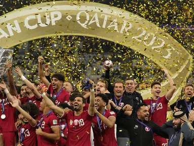Para pemain Qatar mengangkat trofi saat merayakan gelar juara setelah menumbangkan Yordania di laga puncak Piala Asia AFC Qatar 2023 di Stadion Lusail, Doha, pada 10 Februari 2024. (Giuseppe CACACE/AFP)