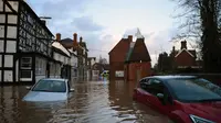 Air banjir mengelilingi mobil-mobil yang ditinggalkan di Tenbury Wells, di Inggris barat, setelah Sungai Teme meluap pada hari Minggu. (Source:Oli Scarff/AFP/Getty Images)