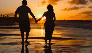 Sepasang kekasih yang sedang menikmati suasana di pantai. (dok. Unsplash.com/Igor Rodrigues)