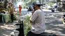 Pembeli membawa cangkang ketupat menggunakan sepeda motor di kawasan Palmerah, Jakarta, Minggu (18/7/2021). Pemberlakuan PPKM Darurat membuat penjualan cangkang ketupat jelang Idul Adha tahun ini sepi pembeli. (Liputan6.com/Faizal Fanani)