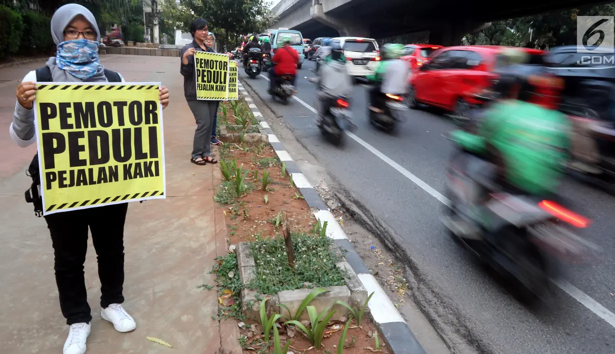 Aktivis Koalisi Pejalan Kaki melakukan aksi peduli pejalan kaki di kawasan pedestrian Kasablanka, Jakarta, Kamis (22/8). Mereka menyerukan agar tidak menggunakan trotoar sebagai tempat parkir dan berjualan.(Liputan6.com/JohanTallo)