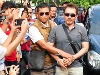 Ketua Umum Persatuan Artis Film Indonesia (PARFI) Gatot Brajamusti alias Aa Gatot dikawal petugas saat tiba di rumahnya di kawasan Pondok Pinang, Jakarta, Kamis (1/9). (Liputan6.com/Yoppy Renato)