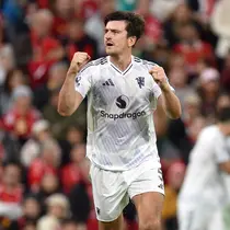 Bek Manchester United, Harry Maguire, merayakan golnya ke gawang Liverpool di Anfield, Minggu (19/10/2025). (AFP/Peter Powell)
