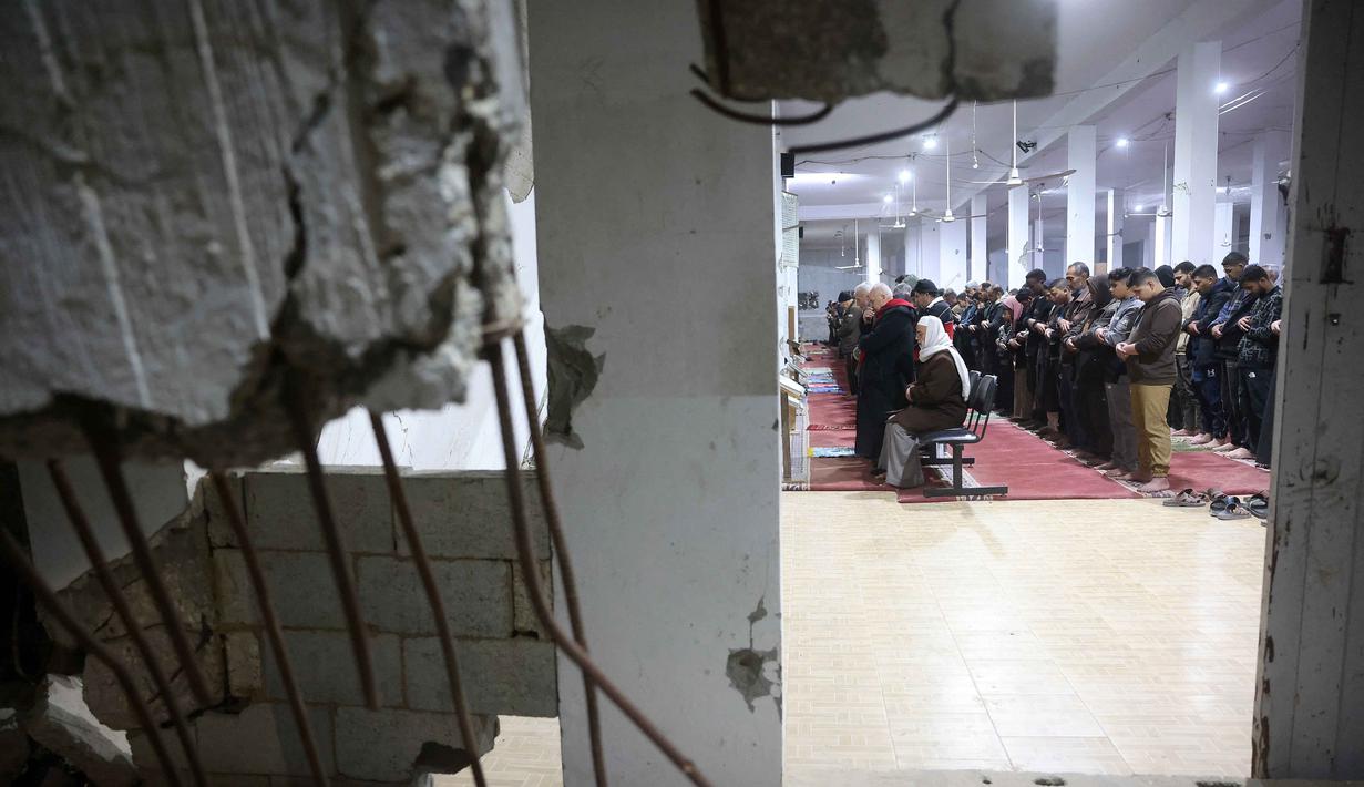10 malam terakhir bulan suci Ramadan, khususnya pada malam ganjil, umat Islam sangat dianjurkan untuk meningkatkan ibadah atau amalan. Tampak dalam foto, umat Muslim melaksanakan salat malam di Masjid Mahaba yang rusak selama perang Israel-Hamas di Khan Yunis, Jalur Gaza selatan pada Senin 16 Maret 2026. (Bashar Taleb/AFP)